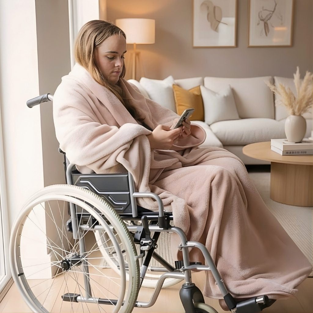 Lady in a wheelchair wrapped in a blanket, using a smartphone in a cozy living room.